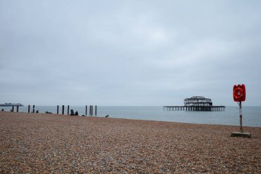 Dur işareti olan bir sahil ve arka planda bir iskele.