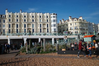 Sahilde yürüyen bir grup insan.