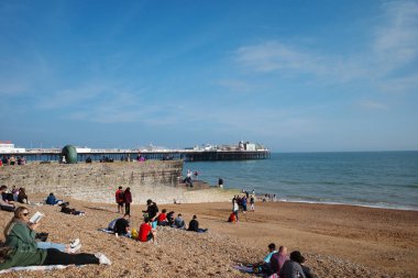 Sahilde oturan bir grup insan.