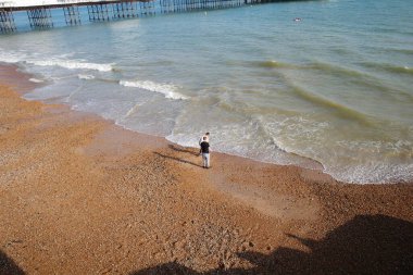 Okyanusun kıyısındaki sahilde duran bir adam.