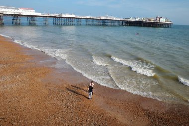 Sahilde durmuş uçurtma uçuran bir insan.