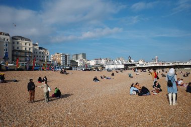 İnsanların oturduğu ve üzerinde durduğu bir kumsal.