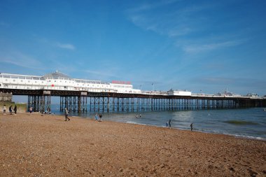 Sahilde yürüyen insanların olduğu bir iskele.