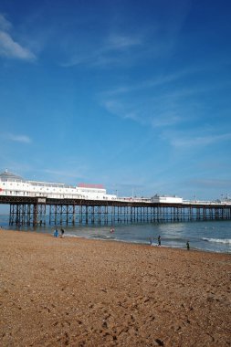 Sahilde yürüyen insanların olduğu bir iskele.