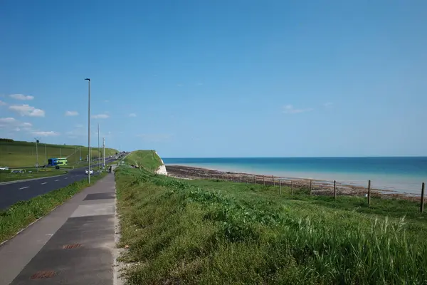 Okyanusun yanında çitleri olan bir yol.