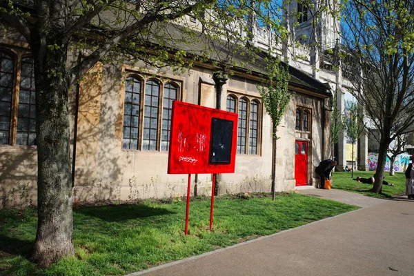 Bir binanın önündeki kaldırımda kırmızı bir tabela.