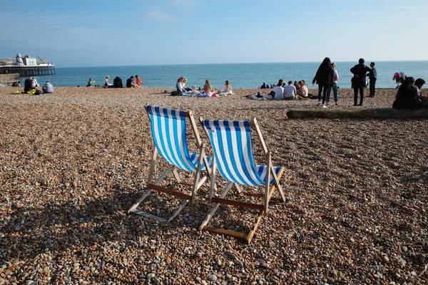 Bir çakıl taşlı plajda iki plaj sandalyesi