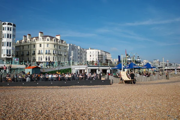 Kumsalda insanların oturduğu bir kumsal ve şemsiyeler.