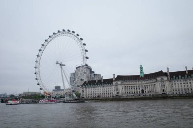 Büyük bir binanın önünde dönme dolap.