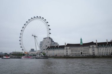 Büyük bir binanın önünde dönme dolap.