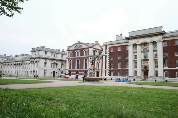 Saat kulesi ve çimenli bir alanı olan bir bina.