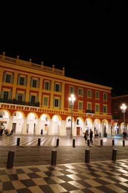 Meydanın ortasında saat kulesi olan büyük bir bina.