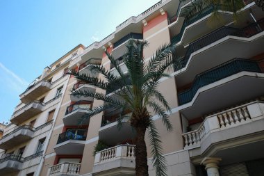 Balkonları ve balkonları olan yüksek bir bina.