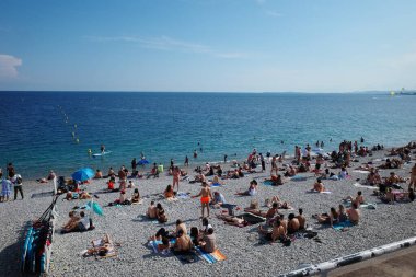 Kalabalık bir plaj içinde insanlar var.