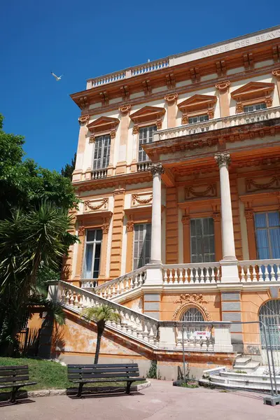 Merdiveni ve bankı olan büyük bir bina.