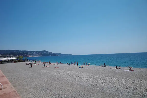 Üzerinde insanlar olan bir sahil ve mavi bir gökyüzü.