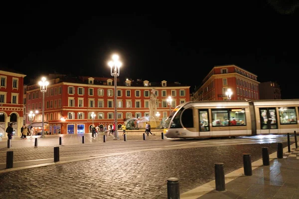 Bir binanın önündeki raylarda bir tren.