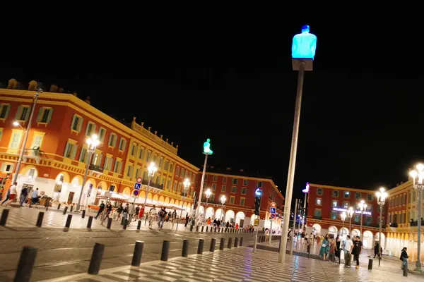 Geceleri şehir meydanında insanlar geziniyor.