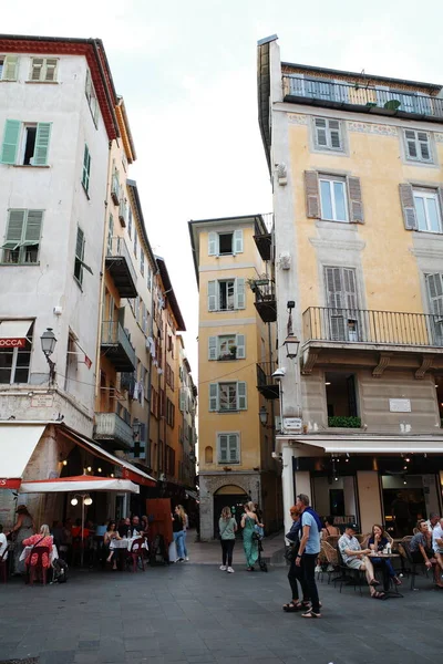 Bir grup insan şehir meydanında masalarda oturuyor.