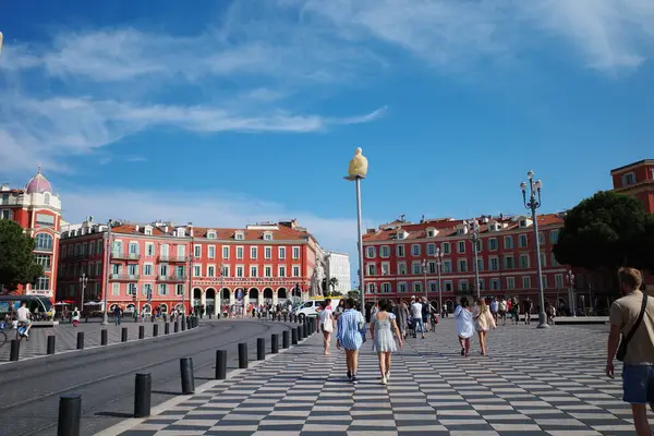 Damalı bir caddede yürüyen bir grup insan.