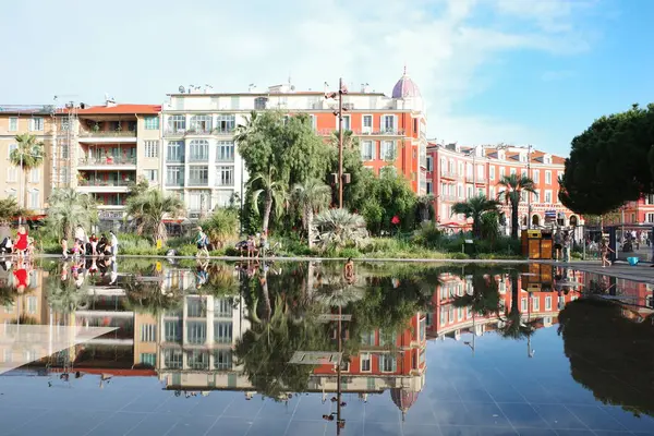 Bir binanın yansıması olan bir şehir meydanı.