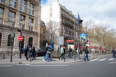 Bir grup insan caddeden karşıya geçiyor.