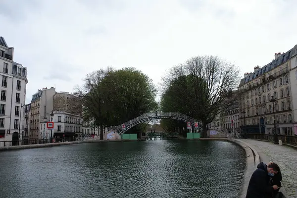 Nehrin yanındaki bankta oturan bir kadın.