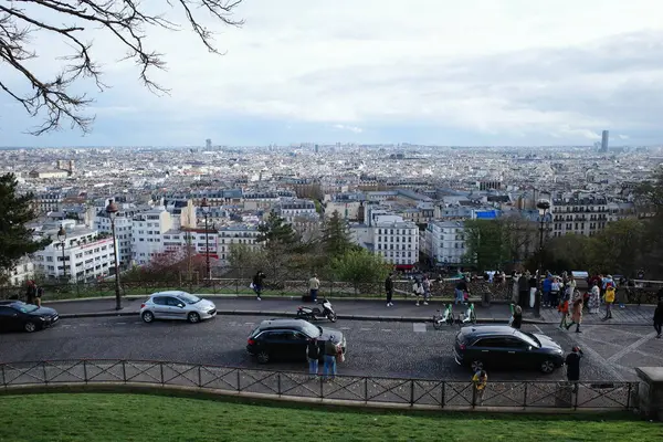 Bir grup insan otoparkta arabalarıyla tepede dikiliyorlar.