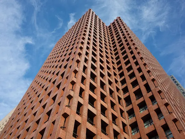 Tepesinde saat olan yüksek tuğlalı bir bina.