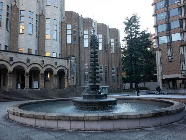 Arka planda bina olan bir avluda çeşme.