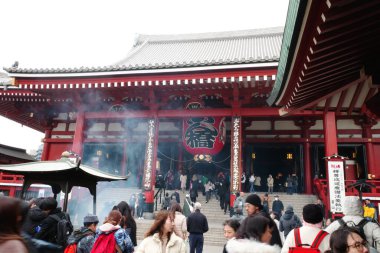 Bir grup insan binanın önünde duruyor.