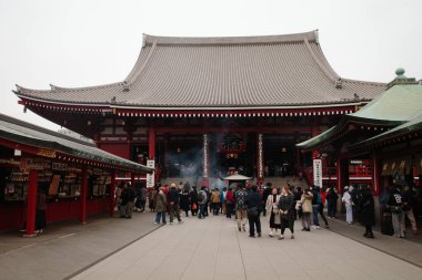 Bir grup insan binanın önünde duruyor.