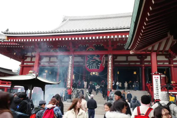 Bir grup insan binanın önünde duruyor.