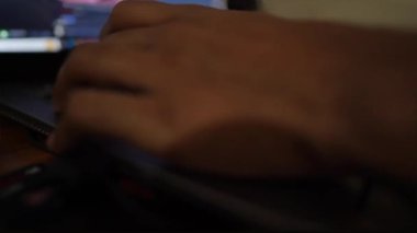 Loş bir ortamda dizüstü bilgisayarda klavyeye yazı yazan birinin yakın plan görüntüsü.