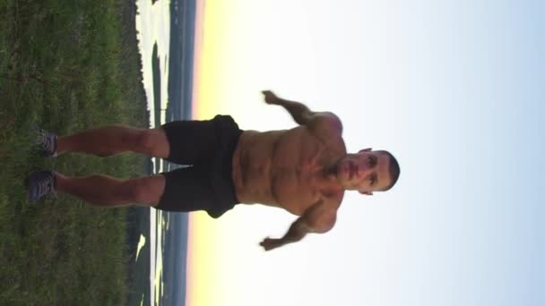 Tepede Isınan Kaslı Bir Adam Yerinde Zıplıyor Dikey Çekim — Stok video