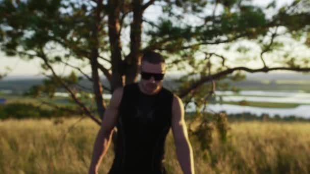 Homem Musculoso Usando Óculos Sol Caminha Até Uma Câmera Campo — Vídeo de Stock