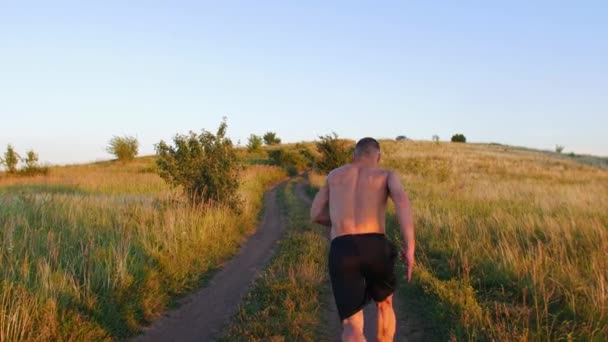 Uomo Muscoloso Senza Maglietta Che Corre Sulla Collina Tramonto Mid — Video Stock