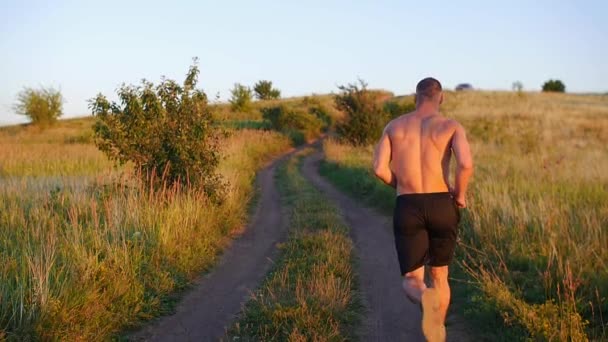 Hombre Musculoso Sin Camisa Corriendo Por Colina Atardecer Cámara Lenta — Vídeos de Stock