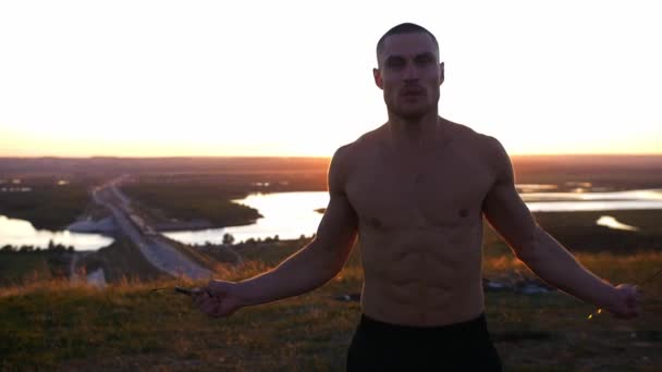 Gün Batımında Ipin Üzerinden Atlayan Kaslı Yakışıklı Üstsüz Bir Adam — Stok video