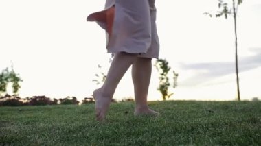 Çimenlerin üzerinde çıplak ayakla dans eden bir kadın. Orta çekim