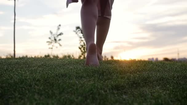 遅い動きで素足で草の上を歩く女性 ミッドショット — ストック動画