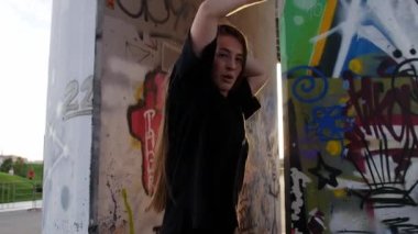 08-13-22 RUSSIA, KAZAN: Grafiti arka planında dans eden genç kadın. Orta çekim