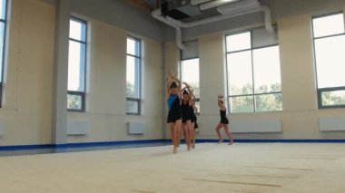 Altı jimnastikçi kızın grup dansı performansı. Orta çekim
