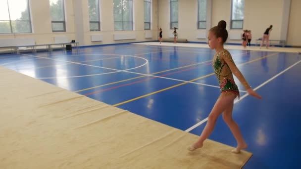体育馆里的体操训练 一个小女孩跑起来准备跳一跳 — 图库视频影像