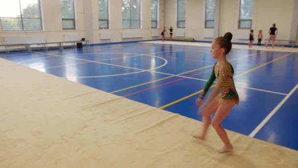 体育馆里的体操训练 一个小女孩在排练她的表演 — 图库视频影像