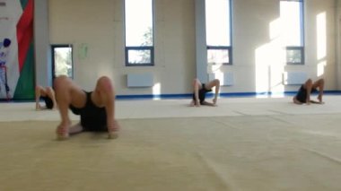 18-08-2022 RUSSIA, KAZAN: Bir grup küçük kız spor salonunda jimnastik yapıyor. Orta çekim
