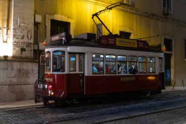 10-29-2022 LISBON, PORTUGAL: raylarda insanların olduğu kırmızı tramvay. Orta çekim