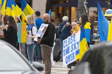 10-29-2022 LISBON, PORTUGAL: Lizbon 'da Ukrayna protestosu - mitingde protesto posterleri taşıyan insanlar - erkek ve çocuklu bir kadın. Orta çekim