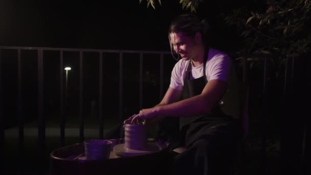Ένας Χαμογελαστός Άντρας Δουλεύει Υγρό Πηλό Νυχτερινό Μπαλκόνι Μεσαίο Πλάνο — Αρχείο Βίντεο