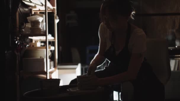 Μια Νεαρή Γυναίκα Φτιάχνει Ένα Πήλινο Δοχείο Στο Σκοτεινό Εργαστήριο — Αρχείο Βίντεο